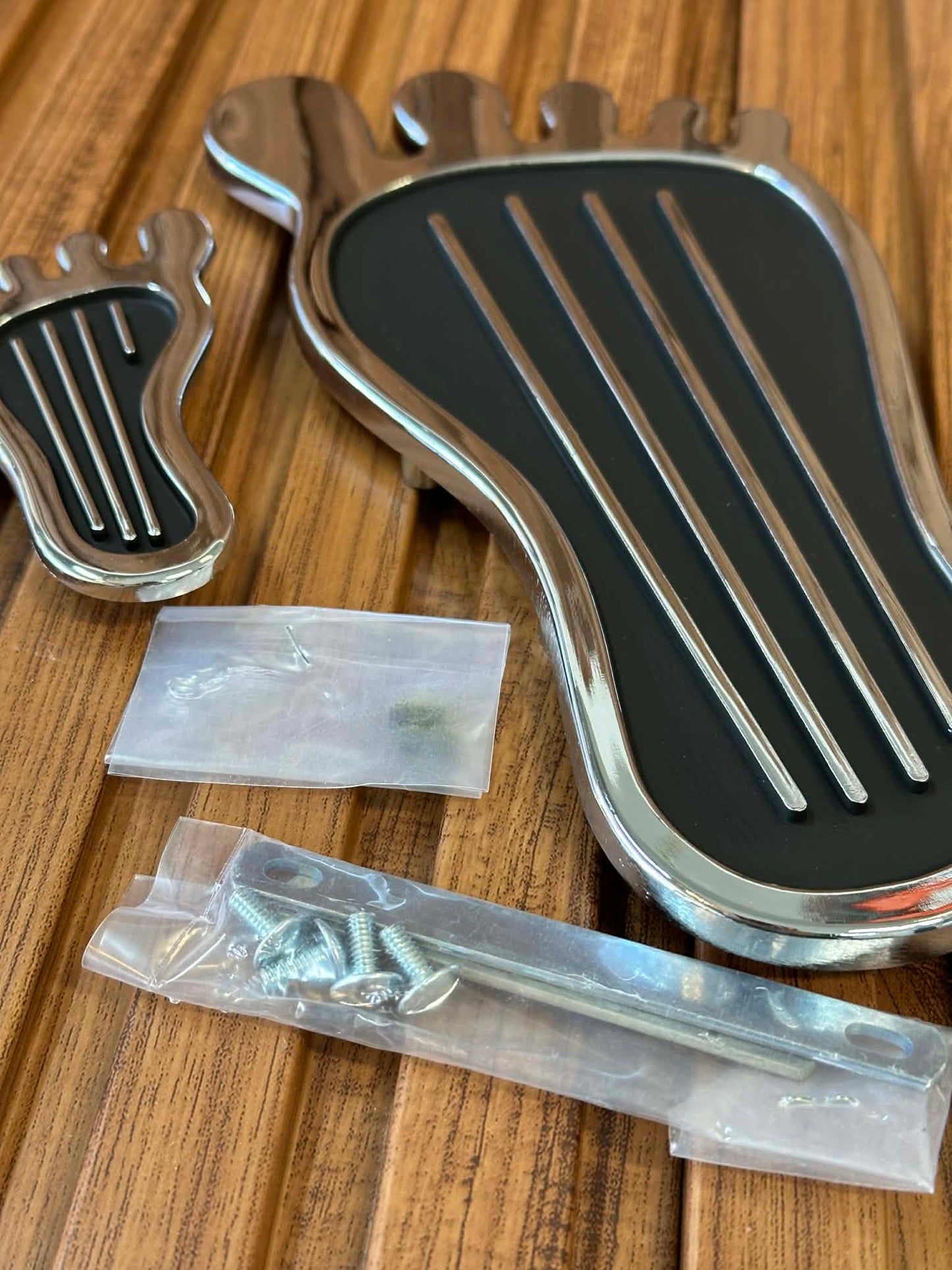 Metallic shoe-shaped object with screws on a wooden surface