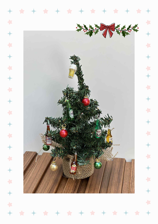 Small decorated Christmas tree on a wooden surface with a plain background